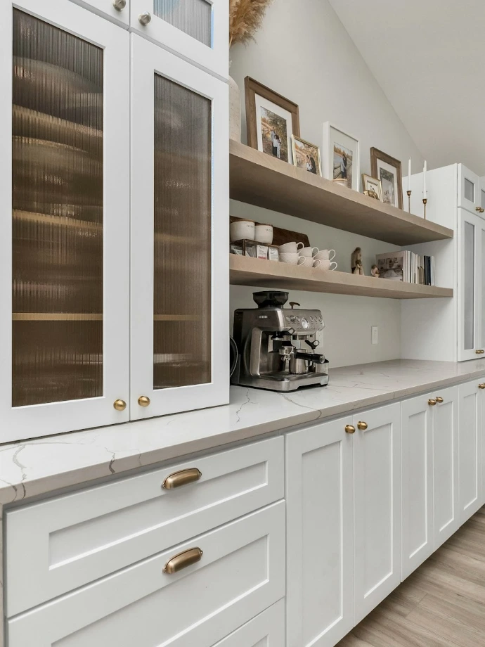 a kitchen with white cabinets and wood floors